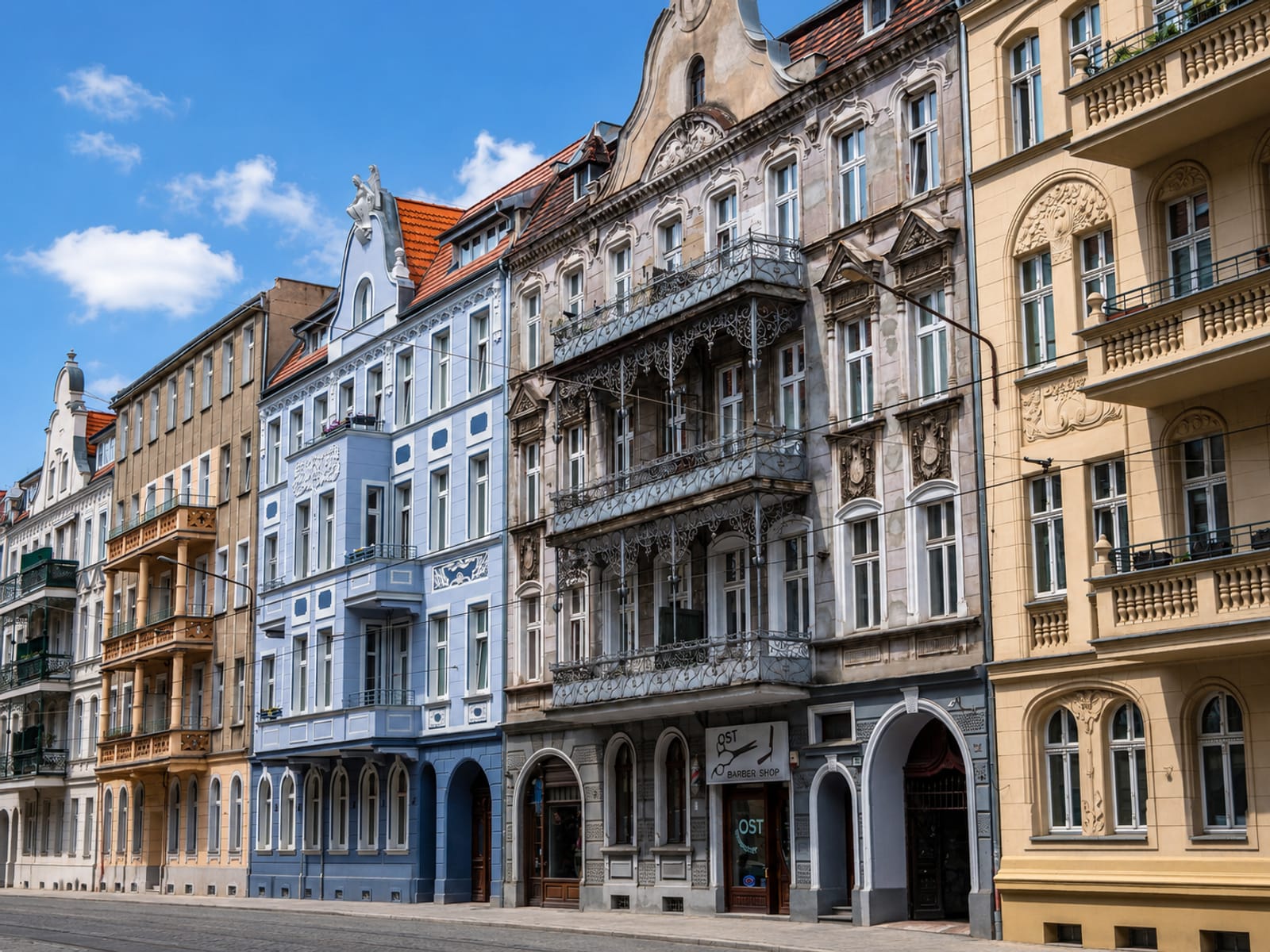 Straßenzeile aus Jugendstil-Mehrfamilienhäusern mit Balkonen und Stuckfassaden